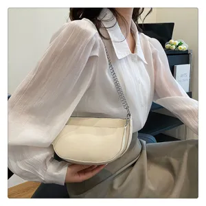 Minimalist crescent saddle shoulder bag detailed view, elegant cream pu leather with chain strap.