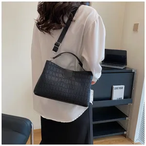 Detailed shot of a stylish black crocodile pattern women shoulder bag with handle.