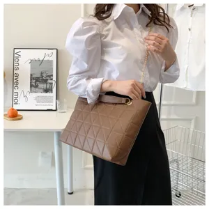 Brown quilted shoulder bag detail, stylish chain strap and elegant modern interior setup.