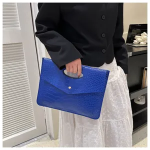 Chic borsa pochette in coccodrillo blu con manico ad anello, dettaglio accessorio moda.
