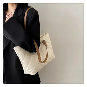Detailed view of casual quilted tote bag with brown straps, stylish daily commuter handbag design.