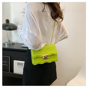 Green wavy flap shoulder bag detail, stylish chain strap and metal clasp design for women.