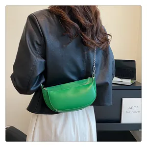 Green leather saddle bag for women, stylish shoulder bag with metal chain strap for daily wear.