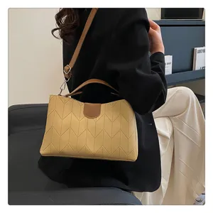 Detailed shot of the chic quilted yellow shoulder bag with elegant brown contrast handle.