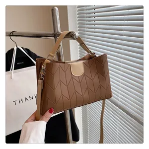 Detailed view of trendy brown patterned crossbody tote handbag with comfortable handle and strap.
