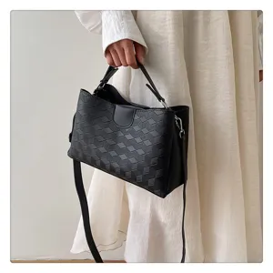 Detailed view of black PU leather shoulder bag featuring stylish geometric woven texture design.