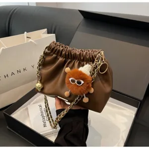 Brown pleated chain shoulder bag with cute plush charm, stylish chic bucket bag for women.