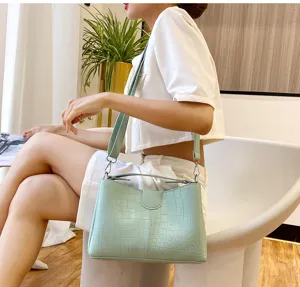 Crocodile pattern shoulder bag detail view, elegant light green leather handbag for women.