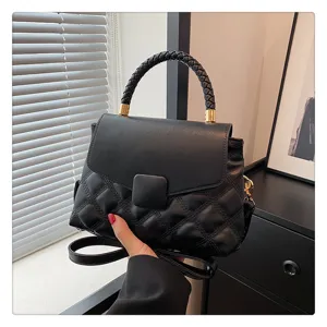 Black quilted flap bag with braided top handle, minimalist solid color crossbody shoulder bag.