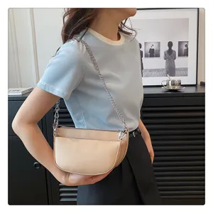 Stylish women beige saddle shoulder bag with metallic chain strap, vintage crescent design.