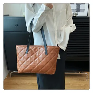 Detail view of the brown quilted tote bag showing fine stitching and texture in daily scene.