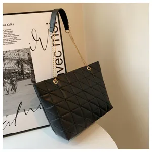 Detailed view of black quilted shoulder bag, showing leather texture and stylish metal chain strap.