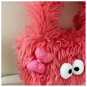 Pink fluffy shoulder bag detail featuring cute cartoon plush eyes and glossy bow decoration.