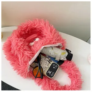 Close-up of fluffy pink monster plush shoulder tote bag showing spacious interior capacity.