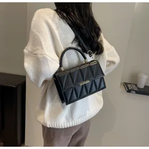Detailed view of the stylish black quilted crossbody handbag worn by model, chic and elegant.