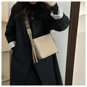 Beige bucket bag with wide strap for women, stylish commuting everyday crossbody bag.