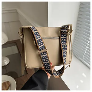 Beige commuting crossbody bag for women with wide strap, stylish casual leather shoulder bag.