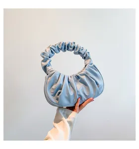 Light blue pleated cloud shoulder dumpling handbag, elegant retro style detail shot.