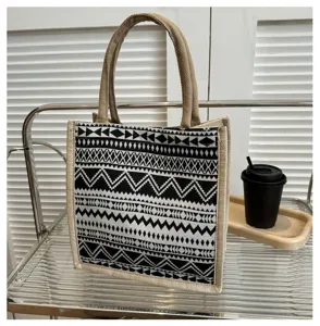 Detailed view of black and white geometric pattern jute canvas tote bag, classic ethnic style.