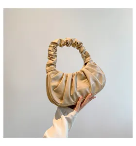 Detail view of a beige pleated cloud bag showing unique retro hobo style handbag details.