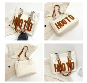 Detailed view of white PU leather tote bag with brown HOOTO letters and chain straps.