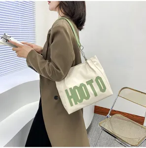 Detailed view of the stylish shoulder bag with green letter patch, large capacity and trendy design.