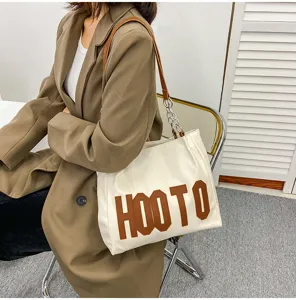 Stylish white tote shoulder bag for women, featuring brown letters and chain strap design.