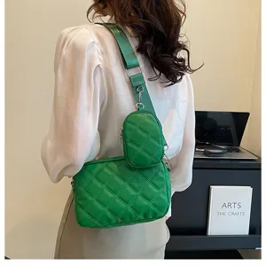 Green quilted crossbody bag detail featuring wide strap and attached mini coin pouch design.