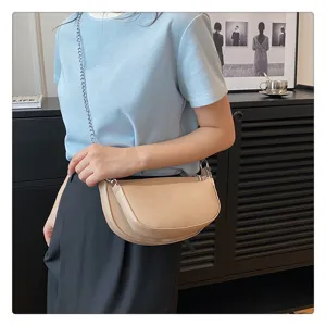 Detailed view of a chic khaki crescent shoulder bag with metallic chain strap and layered design.