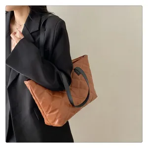 Brown quilted tote bag detailed view, showcasing soft leather texture and stylish stitching.