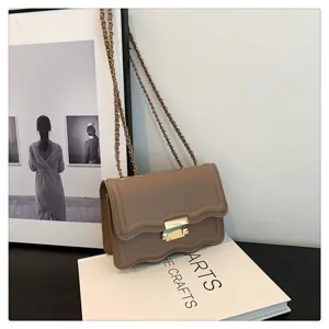 Chic wavy flap chain shoulder bag detail, elegant minimalist design in soft khaki color.