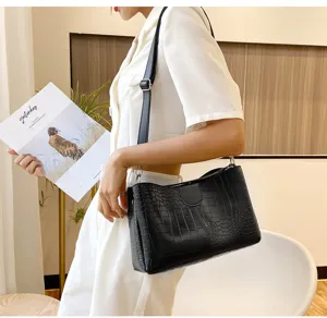 Black crocodile pattern shoulder bag detail, stylish women's crossbody handbag showcasing texture.