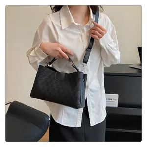 Black geometric embossed PU leather handbag detail, showing texture and handle design.