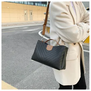 Black shoulder bag detail, elegant V-stitch design, brown top handle, stylish crossbody daily.