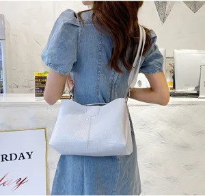 White crocodile pattern shoulder bag detail, elegant PU leather crossbody handbag in scene.