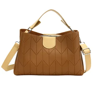 Stylish brown crossbody shoulder bag featuring textured chevron pattern and beige handles.