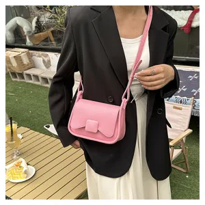 Détail de sac bandoulière rose minimaliste montrant la fermeture et sangle réglable.