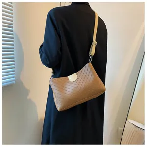 Detail view of the brown chevron shoulder bag with contrasting strap and flap design.