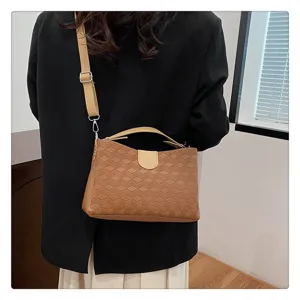 Detailed view of fashionable brown PU geometric textured shoulder bag with handle.