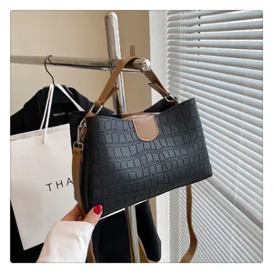 Black crocodile pattern handbag detail, stylish brown handle and metallic hardware design.
