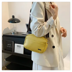 Detailed view of women minimalist PU leather crossbody bag with wide strap, trendy yellow design.