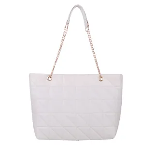 Detailed view of the white quilted tote bag featuring metallic chain handles and stylish design.