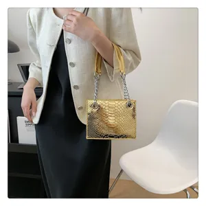 Vue détaillée du sac à main tendance en similicuir doré texturé avec chaîne élégante.
