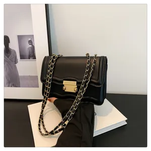 Detailed view of women black leather crossbody bag featuring stylish wave flap and gold chain strap.
