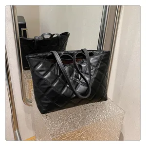 Black quilted tote bag detail view, large capacity casual shoulder bag with stylish diamond pattern.