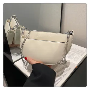 White leather crescent saddle shoulder bag with silver chain detail for women's stylish daily use.
