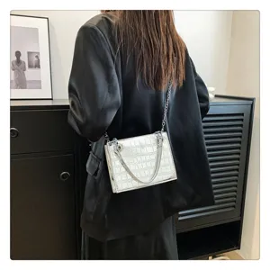 Detail view of the stylish white stone pattern bag showcasing metal chain and texture.