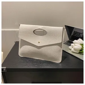 Vista dettagliata della pochette in ecopelle con stampa coccodrillo bianca, manico e bottone.