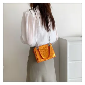 Sac à main femme tendance effet croco métallisé avec bandoulière chaîne et poignée élégante.