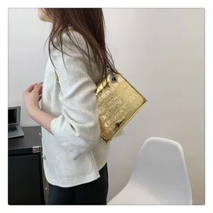Detailed view of the shiny metallic stone pattern chain shoulder bag worn by model.